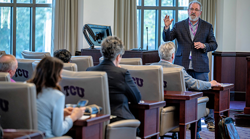 Section Image: Professor teaching in front of group 